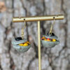 rice with pot earrings on gold jewelry stand