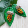 coqui earrings on leaf