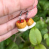 mini mofongo earrings hanging from hand