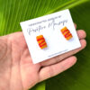 pasteles de yuca earrings on hand with leaf