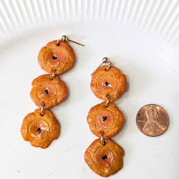 tostones earrings next to penny