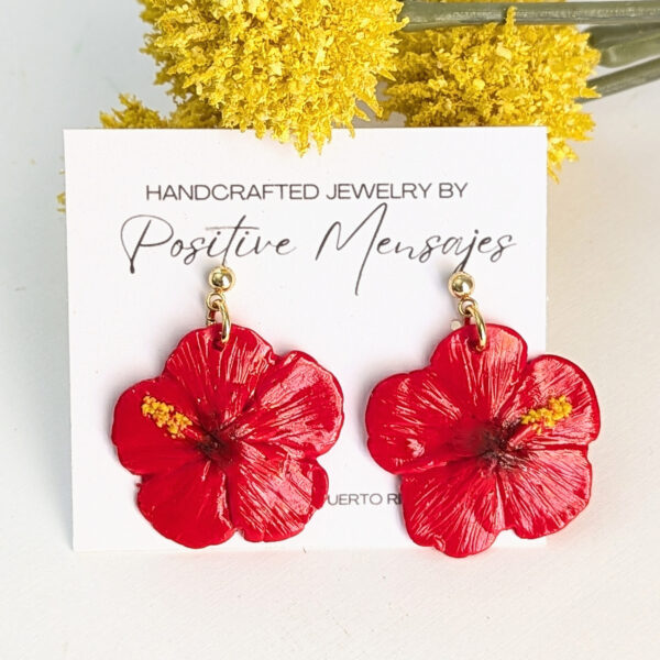 red hibiscus earring on yellow flowers