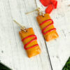 pasteles de yuca earrings on white board