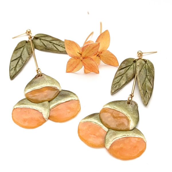 large quenepa fruit jewelry on white board