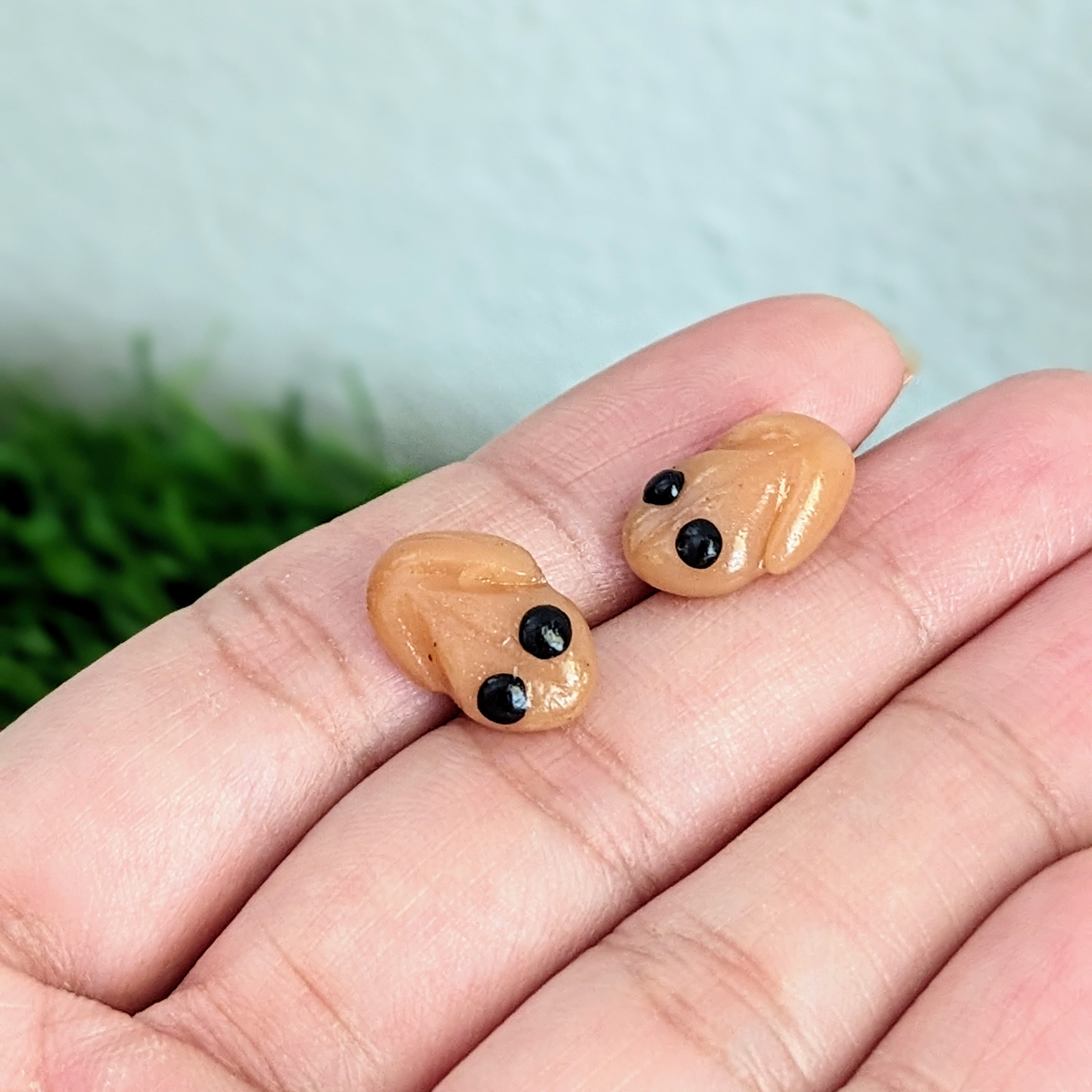 mini coqui earrings shown on hand