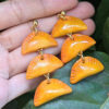 yellow orange empanada earrings on leaf