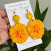 yellow flor de maga earrings on plant