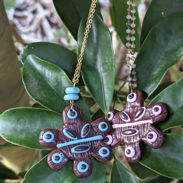 taino necklaces on green plant