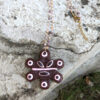 pink and brown taino necklace on cement