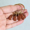 handmade coffee earrings displayed on hand