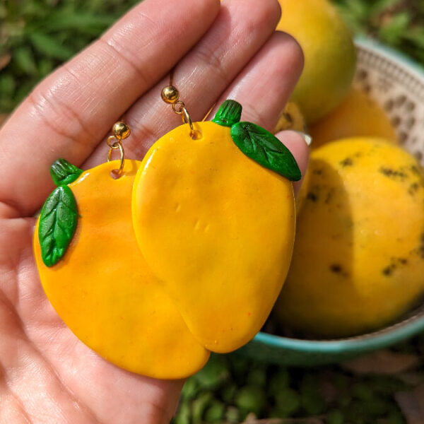 yellow mango earrings in front of mango bowl