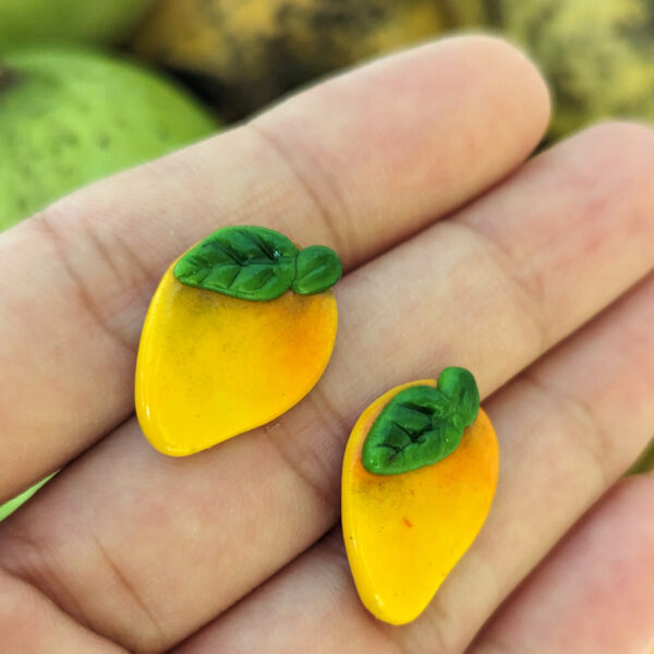 mango earrings in front of mangoes