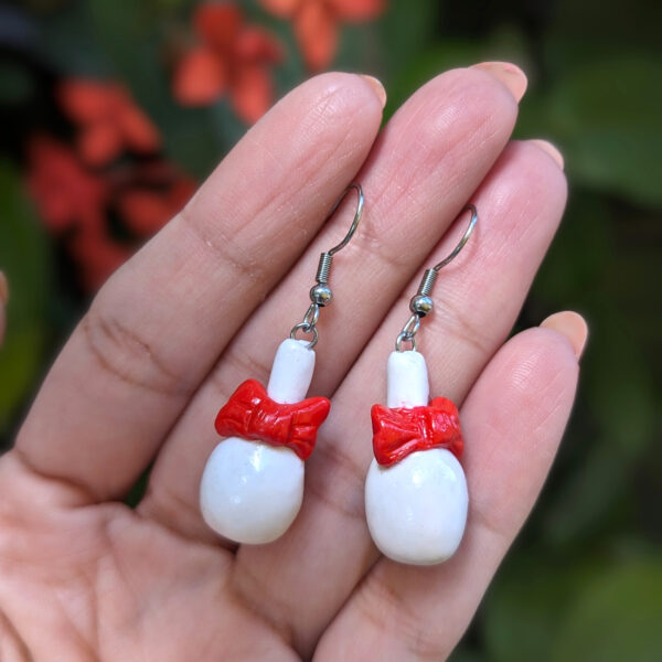 coquito bottle earrings displayed on hand