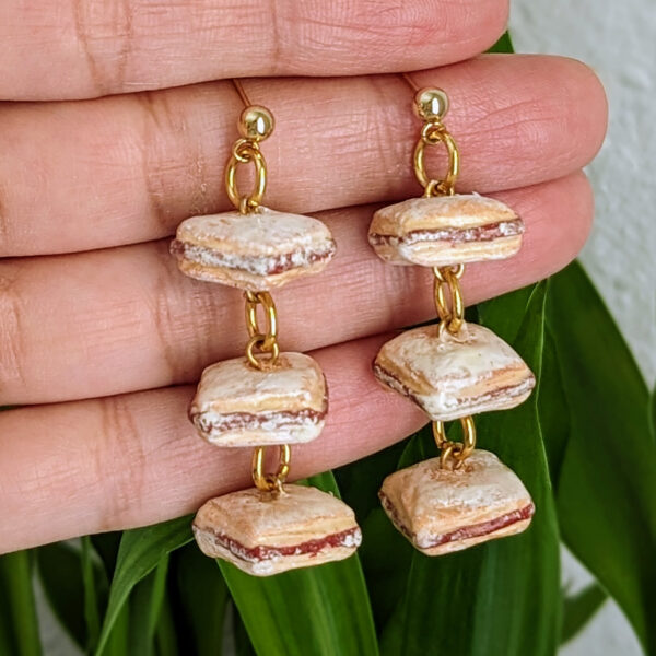 pastelillos earrings hanging on fingers