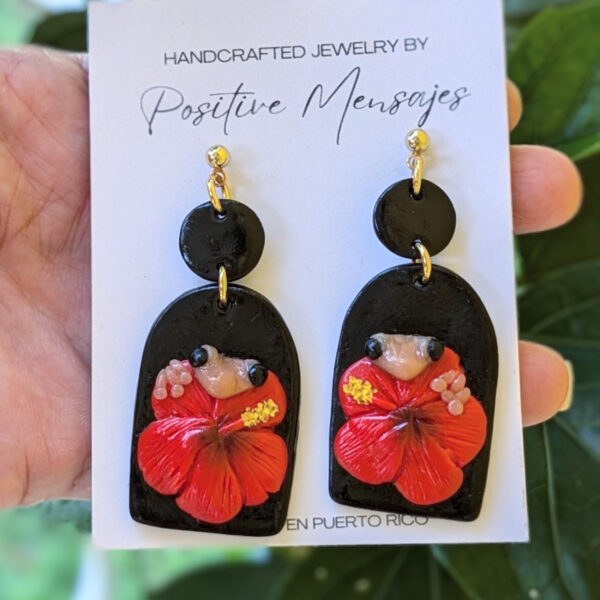 coqui earrings in front of hibiscus plant