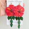 handmade hibiscus earrings with leaves on hand