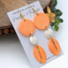 peach and white taino coqui earrings