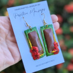 pasteles de guineo earrings in front of flowers