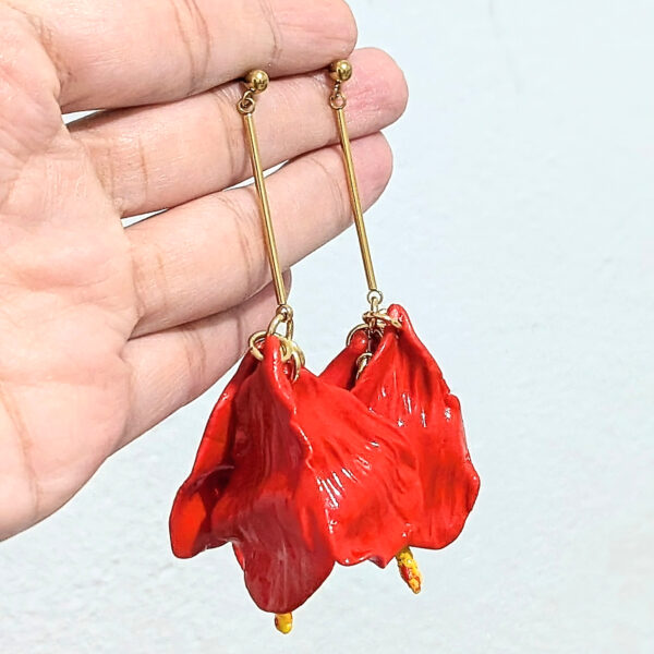 petal flower earrings hanging from artist hand