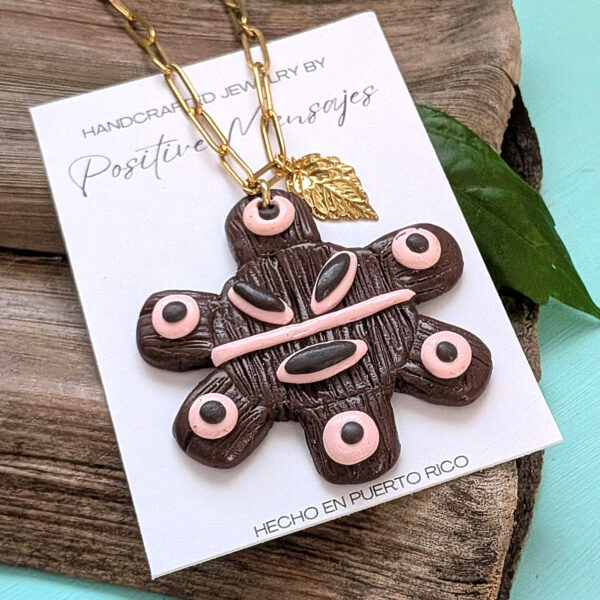 sol taino necklace on a wooden board