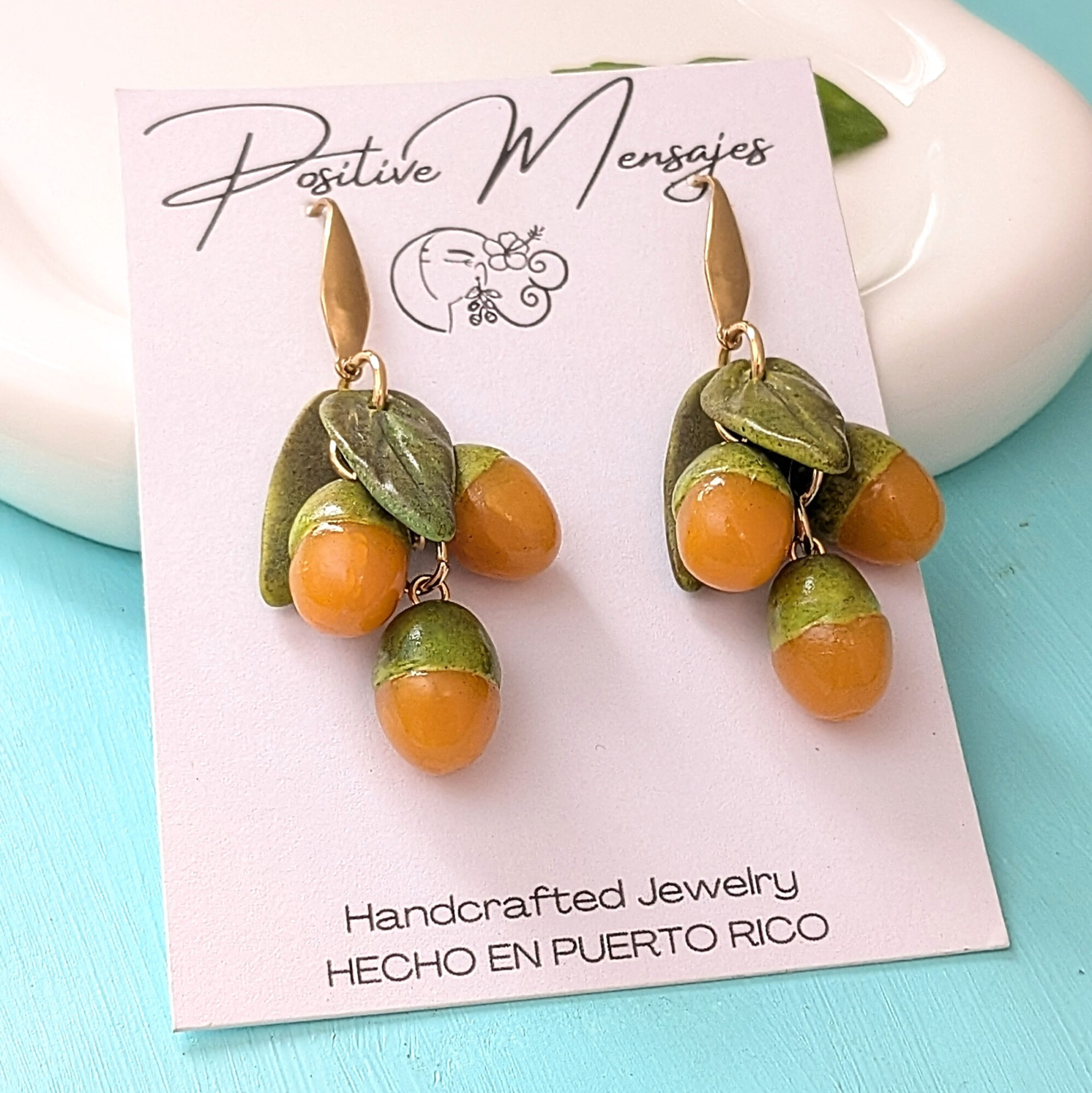 quenepa earrings on white jewelry plate